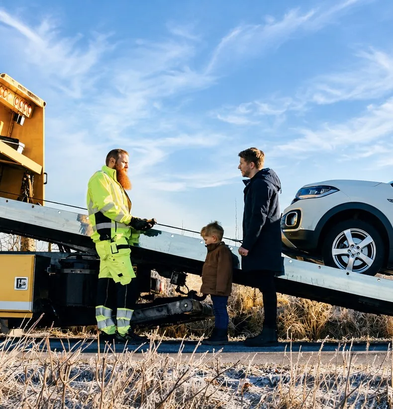 Bärgningsbil lastar en bil på en landsväg